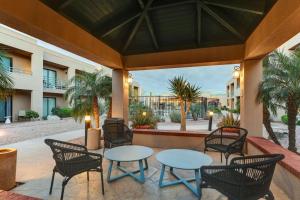 a patio with tables and chairs and palm trees at Sonesta Select Scottsdale at Mayo Clinic Campus in Scottsdale