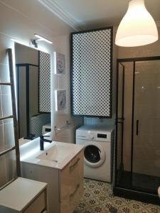 a bathroom with a sink and a washing machine at T1 with pool access concessiao Cabanas Tavira in Tavira
