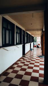 an empty hallway with a checkered floor and windows at Complejo Don Pascual in San Pedro La Laguna