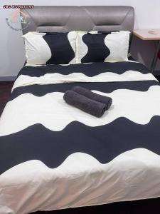 a bed with black and white sheets and pillows at JRC Homestay PJ 1310 Permas Jaya in Johor Bahru