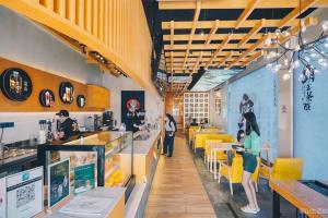 a restaurant with yellow chairs and people sitting at tables at JRC Homestay PJ 1310 Permas Jaya in Johor Bahru