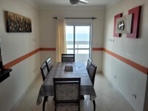 a dining room with a table and chairs and a window at Apartamento de frente para o mar, 3 quartos in Solemar