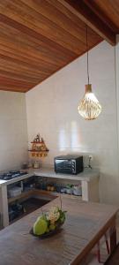 una cocina con una mesa con un bol de fruta. en Chalé em Maraú pertinho da praia en Barra Grande