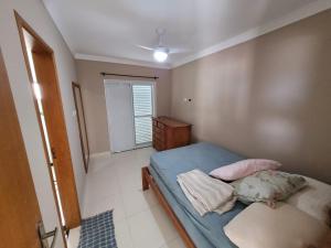 a small bedroom with a bed and a window at Apartamento de frente para o mar, 3 quartos in Solemar +10 photos