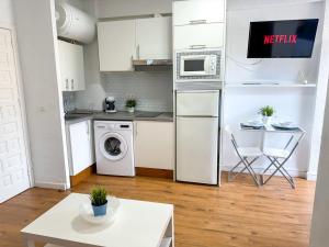 a kitchen with a washer and dryer and a table at Carvajal Beach and Pool ComoTuCasa in Fuengirola