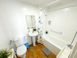 a white bathroom with a toilet and a sink at Carvajal Beach and Pool ComoTuCasa in Fuengirola