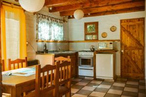 a kitchen with a table and a stove top oven at Cabañas Las Grullas in El Bolsón
