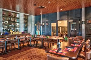 um restaurante com mesas e cadeiras e um bar em Sheraton Mesa Hotel at Wrigleyville West em Mesa