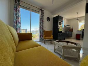 a living room with a couch and a table at Kaz Colibri in Les Anses-dʼArlets