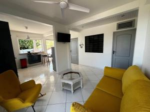 a living room with a yellow couch and a table at Kaz Colibri in Les Anses-dʼArlets