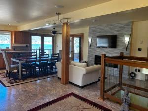 Kootenay, Lakeside Retreat, Main Floor and Walkout في نيلسون: غرفة معيشة مع أريكة بيضاء وغرفة طعام
