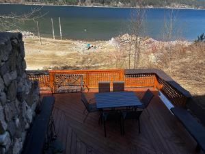 Kootenay, Lakeside Retreat, Main Floor and Walkout في نيلسون: طاولة وكراسي على سطح مطل على الماء
