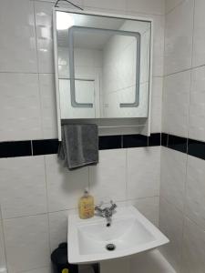 Luxury en-suite bedrooms في ساوثهامبتون: حمام أبيض مع حوض ومرآة