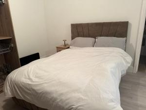 Luxury en-suite bedrooms في ساوثهامبتون: سرير كبير بملاءات ووسائد بيضاء