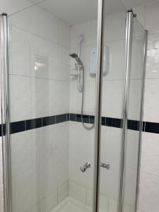 Luxury en-suite bedrooms في ساوثهامبتون: دش مع باب زجاجي في الحمام