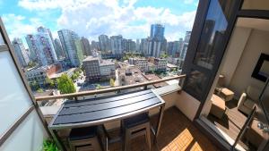 a balcony with a bench and a view of a city at Howe Street Apartment with Views in Vancouver