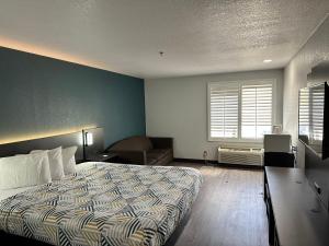 1 dormitorio con cama y pared azul en Motel 6-Lebec, CA, en Lebec