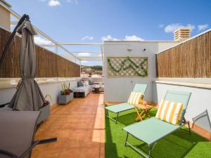 a balcony with two chairs and a table at Casa Maresía Penthouse - Pool & Beach in Sardina