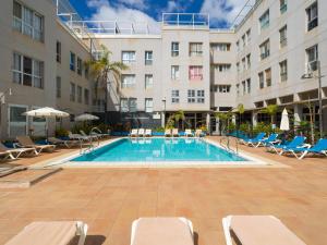 a swimming pool in front of a building at Casa Maresía Penthouse - Pool & Beach in Sardina