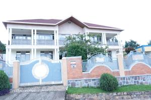 een huis met een blauw hek ervoor bij Green V Apartments in Kigali