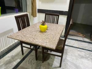 einen Tisch mit einer gelben Vase auf dem Tisch in der Unterkunft Hotel Aspiration in Tājganj