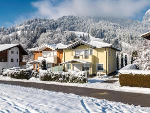 a house in the snow with a mountain in the background at Ferienhaus Gartentraum in Itter