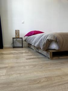 1 dormitorio con 1 cama y suelo de madera en Le Jalet en Provence - Penthouse, en Sisteron