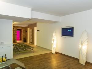 een woonkamer met een bank en een tv aan de muur bij Ferienhaus Gartentraum 2 in Itter