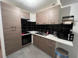 a small kitchen with wooden cabinets and a sink at Le petit Riquewihr in Riquewihr
