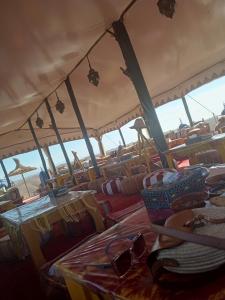 una tienda con sillas y vasos en un barco en Maison linda en Marrakech