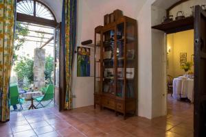 een woonkamer met een boekenplank en een tafel bij Casa di Nonna Maria in Pietraperzia