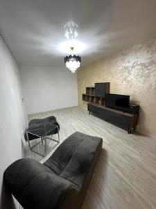a living room with a bed and a television at Apartment Lux in Dobroeşti