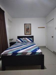 1 dormitorio con 1 cama con edredón azul y blanco en THE ROYAL GUEST HOUSE Hco, en Huanchaco