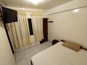 a small bedroom with a bed and a window at THE ROYAL GUEST HOUSE Hco in Huanchaco