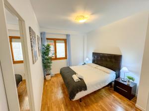 Un dormitorio con una cama con cabecero negro. en Laurel del Pilar ComoTuCasa, en Zaragoza