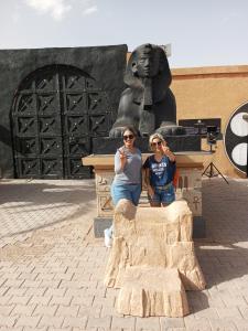 Zwei Frauen sitzen vor einer Statue. in der Unterkunft Maison linda in Marrakesch