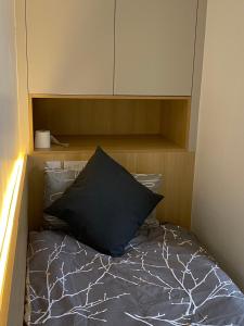 a bed with a black pillow in a room at Not very Quiet but best location in London