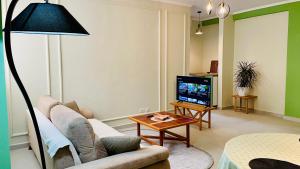 ein Wohnzimmer mit einem Sofa und einem TV in der Unterkunft Green Trails Apartment - Fully renovated with mountain view in Divjaka