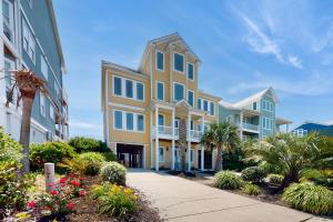 a row of apartment buildings with plants and trees at NTB104 Seas Escape in North Topsail Beach