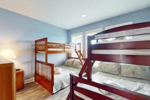 two bunk beds in a bedroom with blue walls at NTB104 Seas Escape in North Topsail Beach