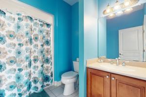 a bathroom with a toilet and a shower curtain at NTB104 Seas Escape in North Topsail Beach +24 photos