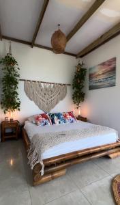 a bed in a room with two plants on the wall at Ritacuba House Boutique in Santa Marta