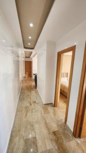 Cette chambre dispose de murs blancs et d'un couloir avec un lit. dans l'établissement Beautiful beachfront apartment, à Rabat