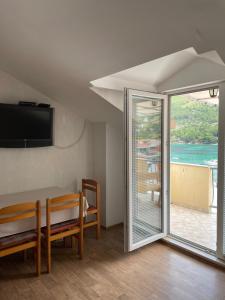 Habitación con mesa de comedor y puerta corredera de cristal. en Apartments by the sea Zuljana, Peljesac - 4577, en Žuljana
