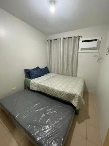una piccola camera con due letti e una finestra di Szedeli Condo unit rental 3 a Città di Iloilo