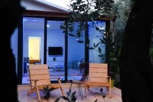 İZNİK Lake House في إزنيق: غرفة معيشة مع كرسيين وتلفزيون