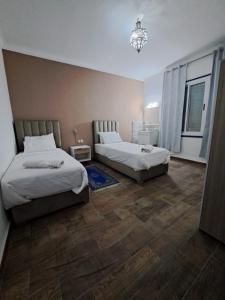 a bedroom with two beds and a chandelier at El Muniria in Tangier