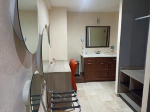 baño con lavabo y escritorio con silla en Hotel Yahalis, en Jilotepec de Abasolo
