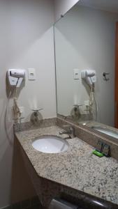 um balcão de casa de banho com um lavatório e um espelho em Hotel Live Logde Vila Mariana Pq Ibirapuera UH-511 em São Paulo
