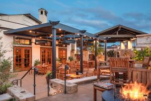 une terrasse avec des tables et des chaises ainsi qu'une cheminée dans l'établissement Casa Munras Garden Hotel & Spa, à Monterey